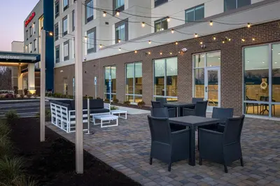 a patio with tables and chairs in front of a building at Hampton Inn & Suites Cincinnati West, Oh in Dent