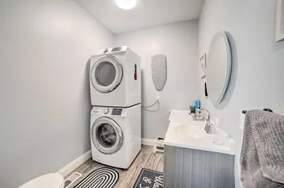 a laundry room with a washing machine and a sink at Spacious Fort Wayne Condo with Porch and Storage! in Fort Wayne