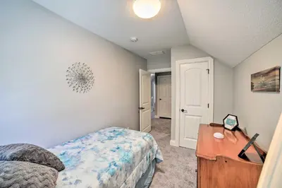 a bedroom with a bed and a table in it at Spacious Fort Wayne Condo with Porch and Storage! in Fort Wayne
