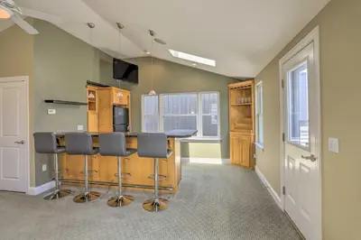 a kitchen with a bar with stools at Central Cleveland Gem with Direct Skyline View! in Cleveland
