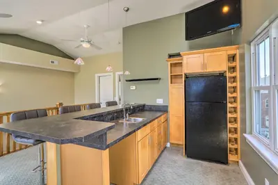 a kitchen with a sink and a black refrigerator at Central Cleveland Gem with Direct Skyline View! in Cleveland