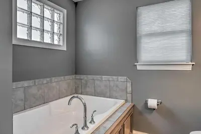 a bath tub in a bathroom with a window at Central Cleveland Gem with Direct Skyline View! in Cleveland