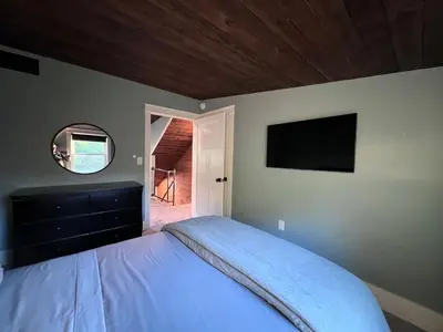 a bedroom with a bed and a tv on the wall at Modern Industrial Farmhouse - The Wayback in Orange