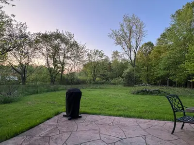 a trash can sitting next to a bench in a park at Modern Industrial Farmhouse - The Wayback in Orange