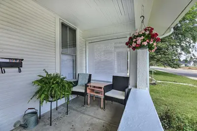 a porch with two chairs and a table with flowers at Pet-Friendly Greenville Home with Private Yard in Greenville