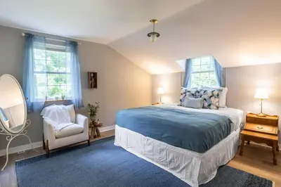 a bedroom with a bed and a chair and a mirror at Lakefront for 8, Near KY Speedway, Belterra Casino in Sparta