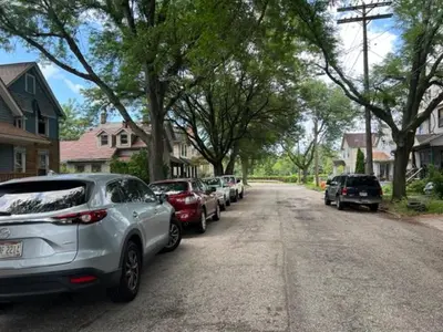 a row of cars parked on the side of a street at Uber Close to Ohio City, Cleveland (Lower) in Cleveland