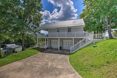 a large white house with a large driveway at Charming Hanoverton Cottage on Guilford Lake! in Lisbon
