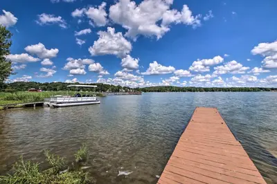 a boat is docked at a dock on a lake at Charming Hanoverton Cottage on Guilford Lake! in Lisbon