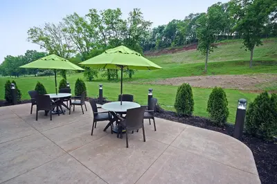 a group of tables and chairs with umbrellas at Comfort Suites Marietta-Parkersburg in Marietta