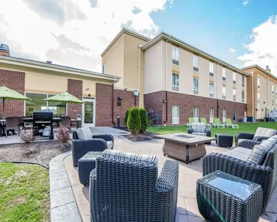 a patio with chairs and a table in front of a building at Comfort Suites Marietta-Parkersburg in Marietta