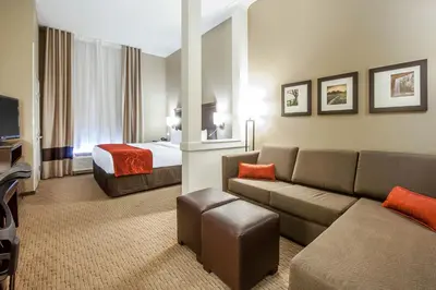 a hotel room with a couch and a bed at Comfort Suites Marietta-Parkersburg in Marietta