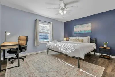 a bedroom with a bed and a desk and a chair at Housepitality - The Sunset House in Columbus