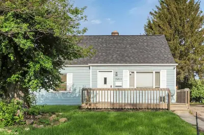 a white house with a wooden fence in the yard at Housepitality - The Sunset House in Columbus