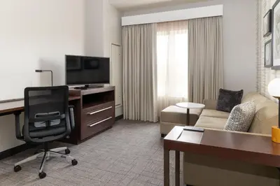 a hotel room with a desk and a living room at Residence Inn by Marriott Columbus Polaris in Columbus