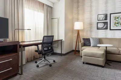 a hotel room with a desk and a chair and a couch at Residence Inn by Marriott Columbus Polaris in Columbus