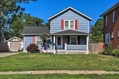 a white house with a red shutter at Lorain Lake Cottage Less Than 1 Mi to Lake Erie Fun! in Lorain