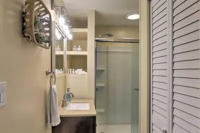 a bathroom with a shower with a sink and a mirror at Lorain Lake Cottage Less Than 1 Mi to Lake Erie Fun! in Lorain