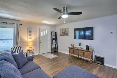 a living room with a blue couch and a tv at Lorain Lake Cottage Less Than 1 Mi to Lake Erie Fun! in Lorain