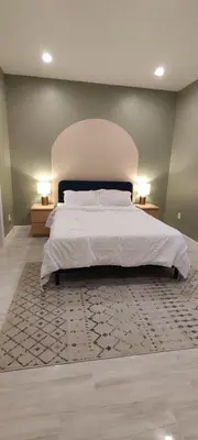 a bedroom with a large white bed with two lamps at Cozy Downtown Loft Apartment in Delaware