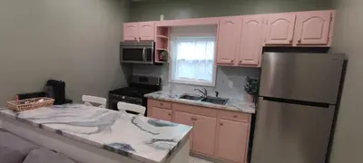 a kitchen with pink cabinets and a refrigerator at Cozy Downtown Loft Apartment in Delaware