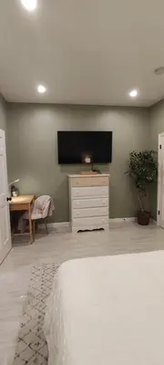 a bedroom with a bed and a flat screen tv at Cozy Downtown Loft Apartment in Delaware
