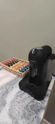 a black coffee maker sitting on a counter next to a basket at Cozy Downtown Loft Apartment in Delaware