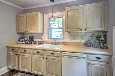a kitchen with wooden cabinets and a sink and a window at Bright Parma Home with Outdoor Space Less Than 10 Mi to Dtwn in Parma