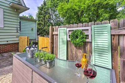 a patio with two glasses of wine and a fence at Bright Parma Home with Outdoor Space Less Than 10 Mi to Dtwn in Parma