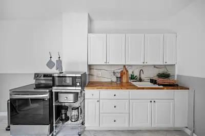 a kitchen with white cabinets and a stove top oven at Center of Little Italy #2 in Cleveland