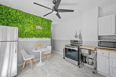 a kitchen with a green wall with a table and chairs at Center of Little Italy #2 in Cleveland