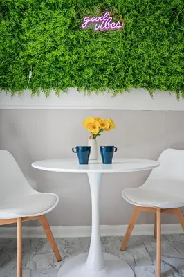 a white table with two vases on it with two chairs at Center of Little Italy #2 in Cleveland