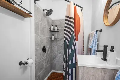 a bathroom with a shower and a sink at Center of Little Italy #2 in Cleveland