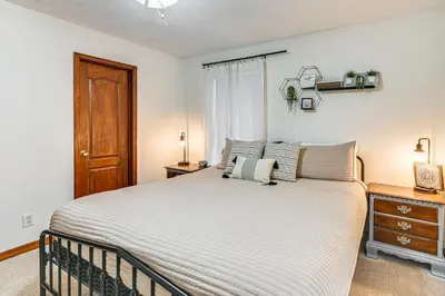 a bedroom with a large bed and a wooden door at Williamstown Gem with Private Pool and Hot Tub! in Williamstown