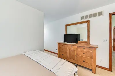 a bedroom with a tv and a dresser with a mirror at Williamstown Gem with Private Pool and Hot Tub! in Williamstown