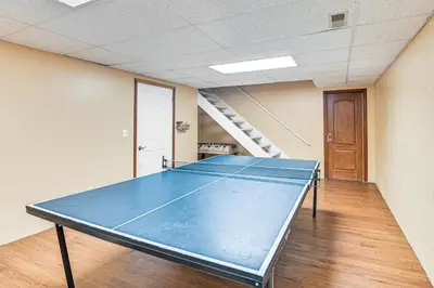 a ping pong table in a room with a staircase at Williamstown Gem with Private Pool and Hot Tub! in Williamstown