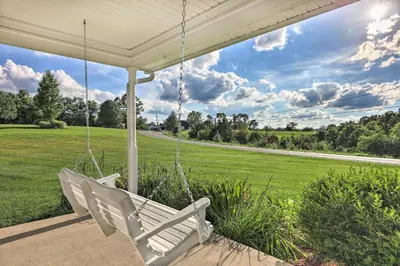 a white porch swing with a view of a field at Williamstown Gem with Private Pool and Hot Tub! in Williamstown