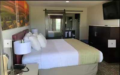 a hotel room with a large bed and a bathroom at Days Inn by Wyndham Bellville Mansfield in Bellville