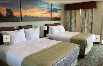 a hotel room with two beds and a painting on the wall at Days Inn by Wyndham Bellville Mansfield in Bellville