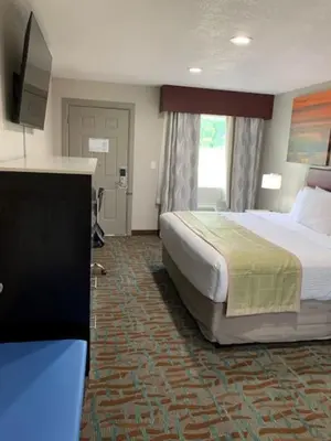 a hotel room with a bed and a flat screen tv at Days Inn by Wyndham Bellville Mansfield in Bellville