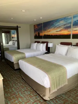 a hotel room with two beds and a painting on the wall at Days Inn by Wyndham Bellville Mansfield in Bellville