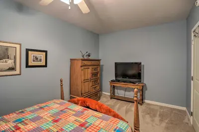 a bedroom with a bed and a flat screen tv at Cheerful Tiffin Digs in the Heart of Downtown in Tiffin