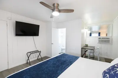 a bedroom with a bed and a flat screen tv at Anchor Bay Inn and Suites in Sandusky