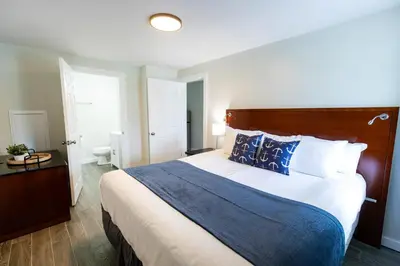 a bedroom with a large bed with blue and white pillows at Anchor Bay Inn and Suites in Sandusky