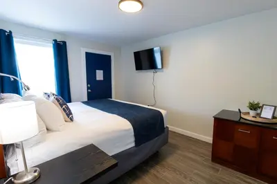 a hotel room with a bed and a tv at Anchor Bay Inn and Suites in Sandusky