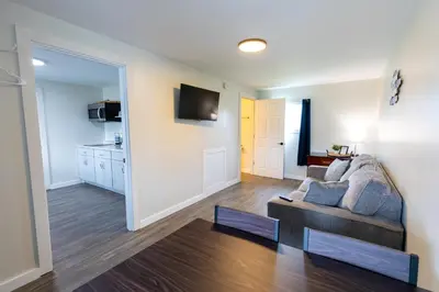 a living room with a couch and a kitchen at Anchor Bay Inn and Suites in Sandusky