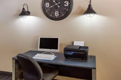 a desk with a computer and a clock on the wall at Best Western Logan Inn in Chapmanville