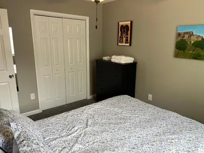 a bedroom with a bed and a door and a dresser at Carter #3 Two bedroom unit near Xavier Downtown in Cincinnati
