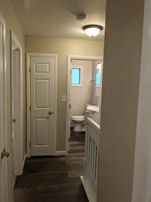 a hallway with a bathroom with a toilet and a door at Carter #5 Two bedroom unit near Xavier Downtown in Cincinnati