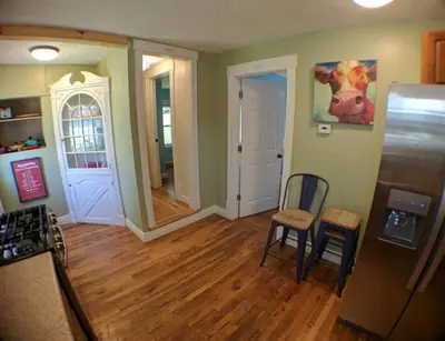 a kitchen with a refrigerator and a table and chairs at Harper Two Bedroom House in Historic Loveland in Loveland